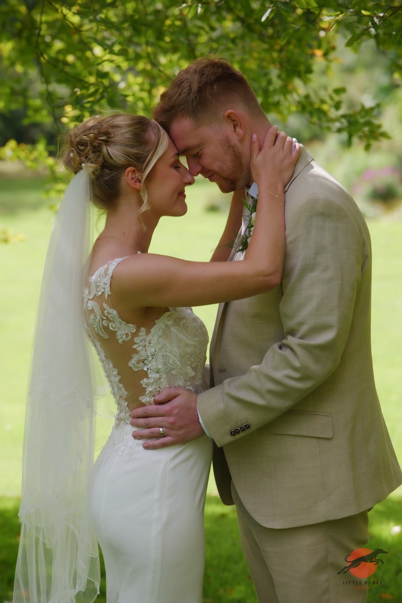 Newlyweds touching foreheads in the garden at Askham Hall near Penrith