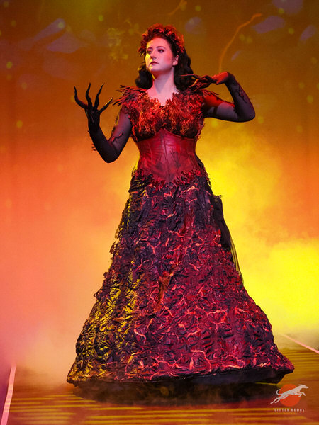 Model wearing Zara Williams’ Pele, Hawaiian goddess of fire and volcanoes, costume against a fiery stage backdrop at University of Huddersfield