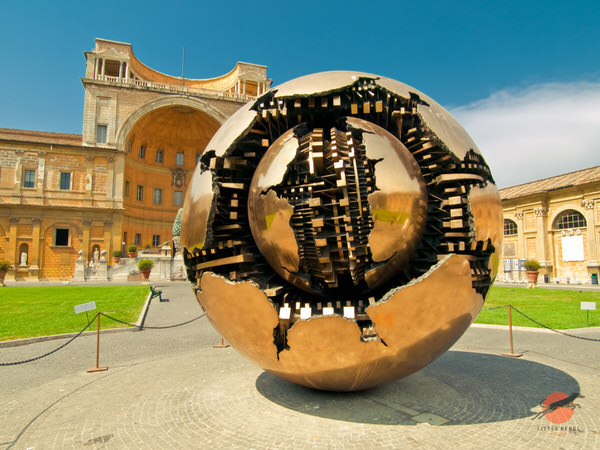 The bronze sculpture is named Sfera con Sfera (Sphere Within Sphere) and was created by Italian sculptor Arnaldo Pomodoro